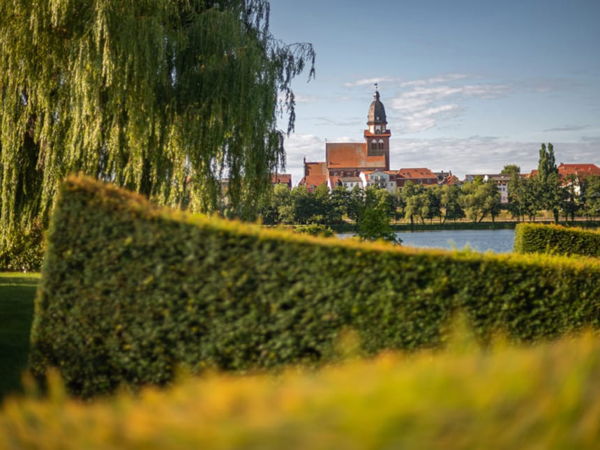 Parkanlage mit Blick auf den See und einer Kirche