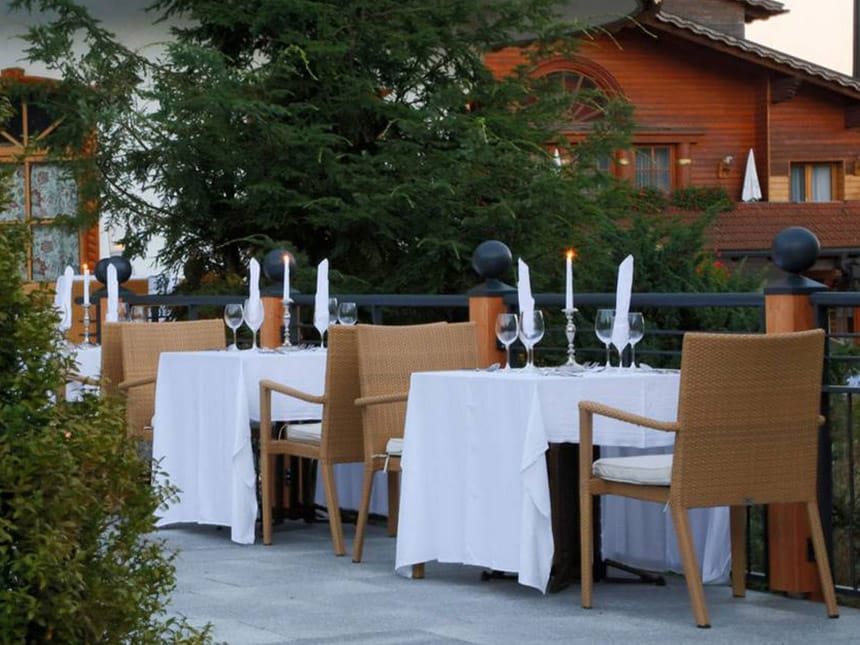 Hotelterrasse am Abend mit gedeckten Tischen