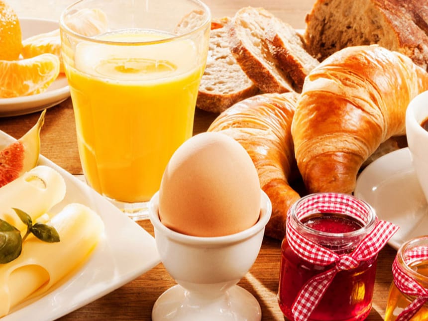 Orangensaft, Ei und eine Auswahl von Brot und Brötchen
