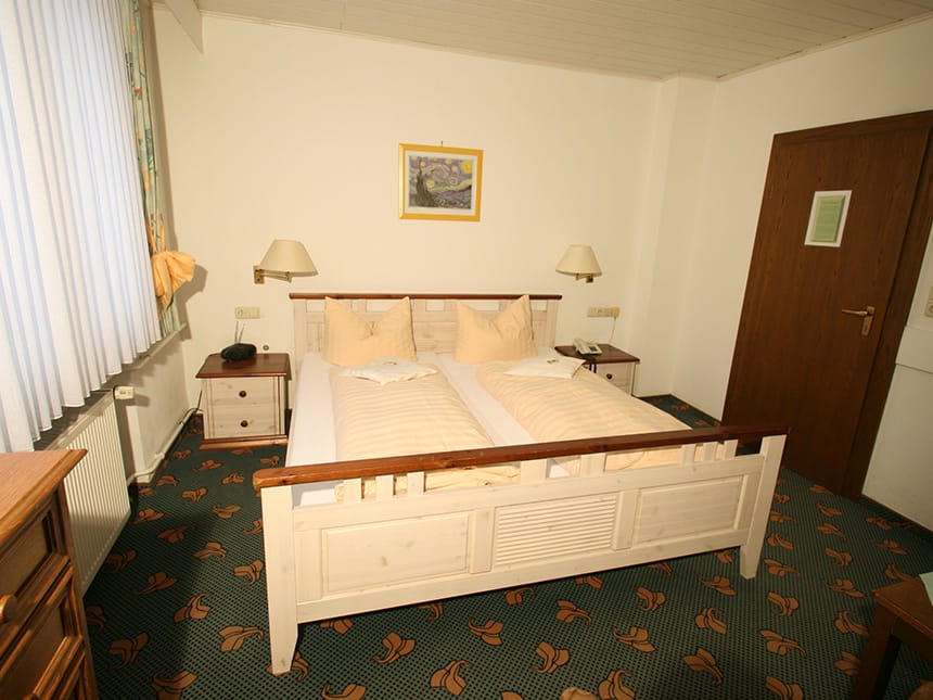 Doppelzimmer Standard mit Doppelbett Nachtischen und Leselampen