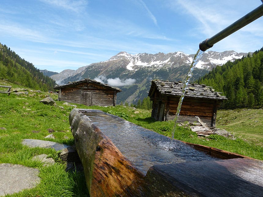 Blick vom Berg mit Wasserquelle und kleinen Holzhütten