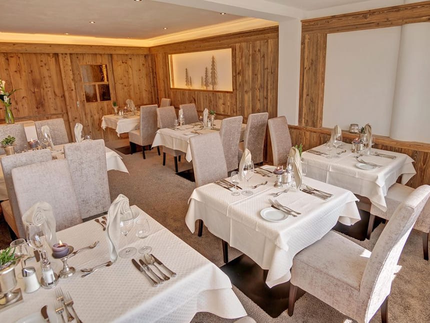 modern eingerichtetes Restaurant mit Polsterstühlen und weiß eingedeckten Tischen