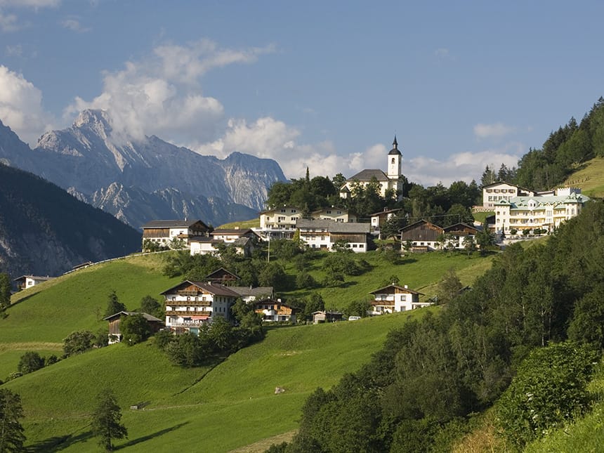 Ort Haiming mit grünen Wiesen und Bergen im Hintergrund