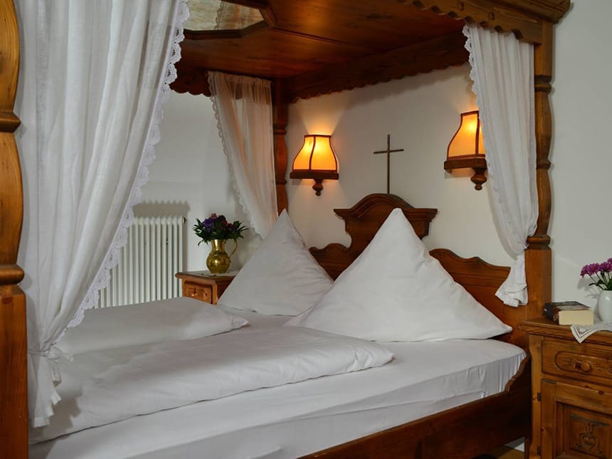 Himmelbett im Doppelzimmer mit Weißer Bettwäsche und Leselampen
