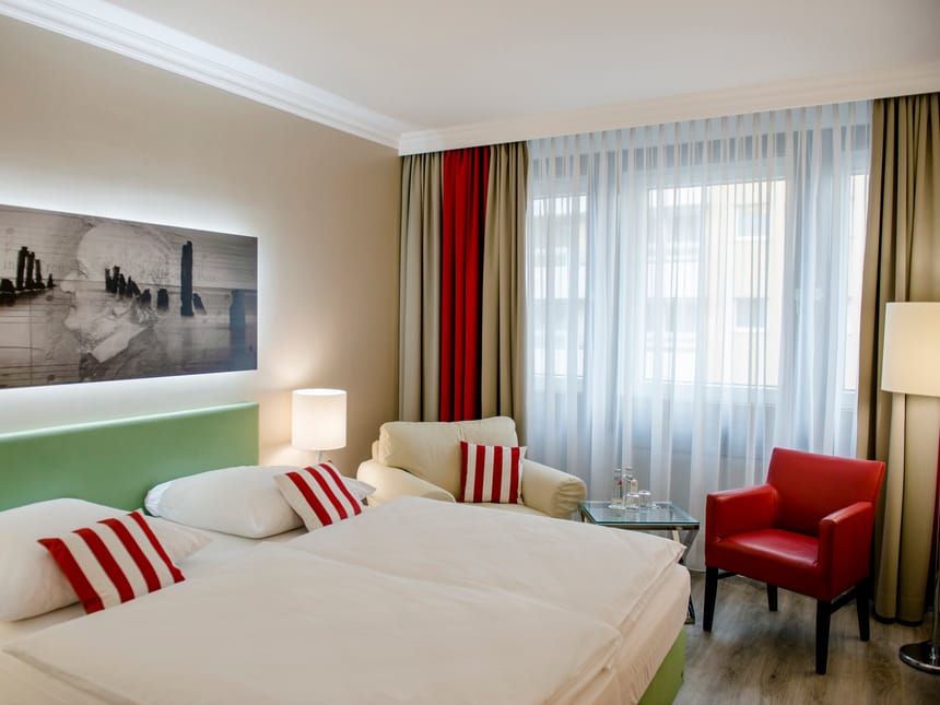 Superior Doppelzimmer mit Doppelbett, rotem und weißem Sessel