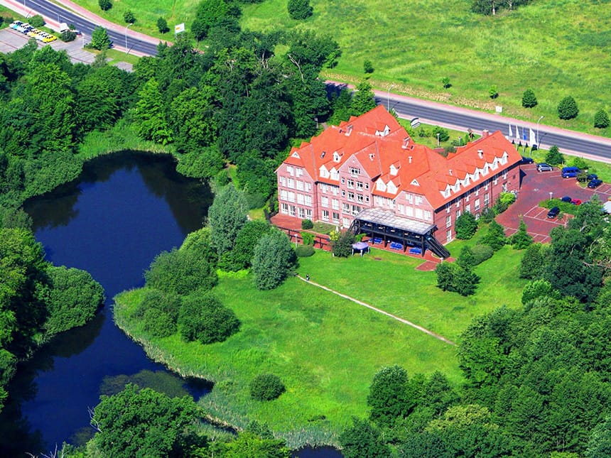 Außenansicht des Park Hotel Fasanerie Neustrelitz mit großem Teich