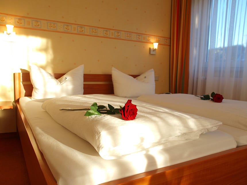Standard Doppelzimmer mit Rosen auf dem Bett