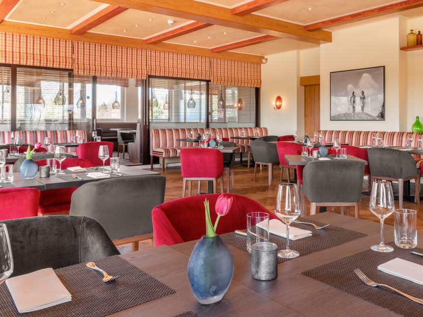 gemütliches Restaurant mit grau und roten Polstermöbeln